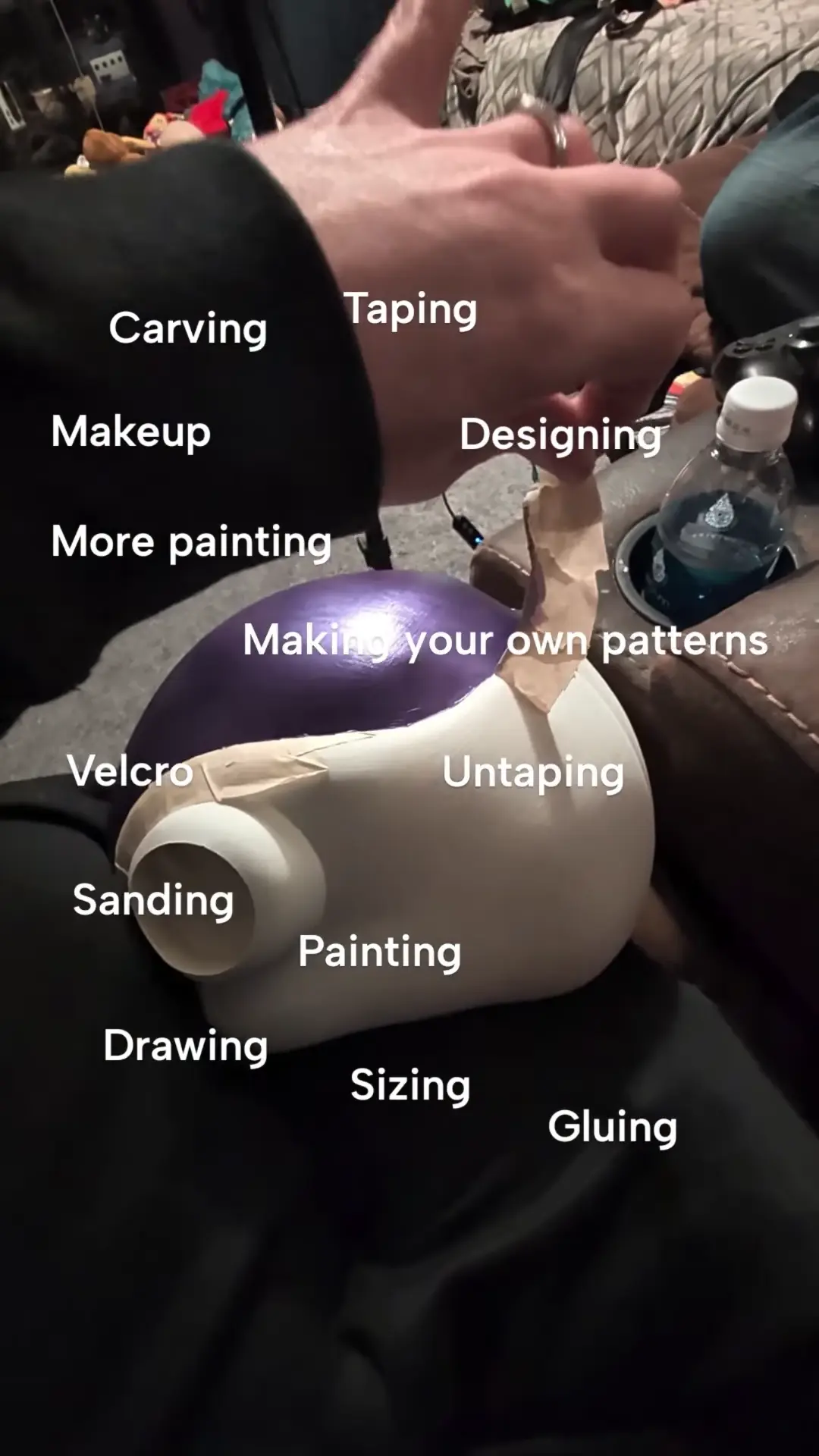 Close-up of Mariah’s hands removing masking tape from the painted Frieza helmet